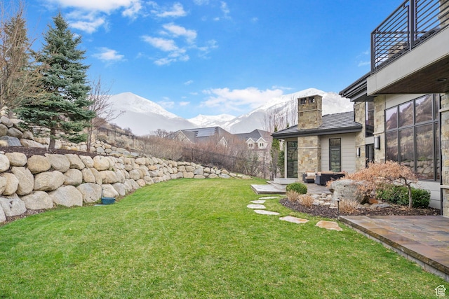 view of yard with fence, a patio, and a mountain view