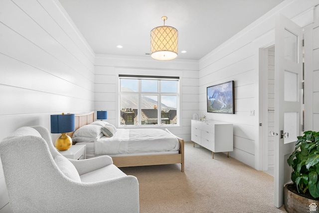 bedroom with ornamental molding, recessed lighting, carpet, and wood walls