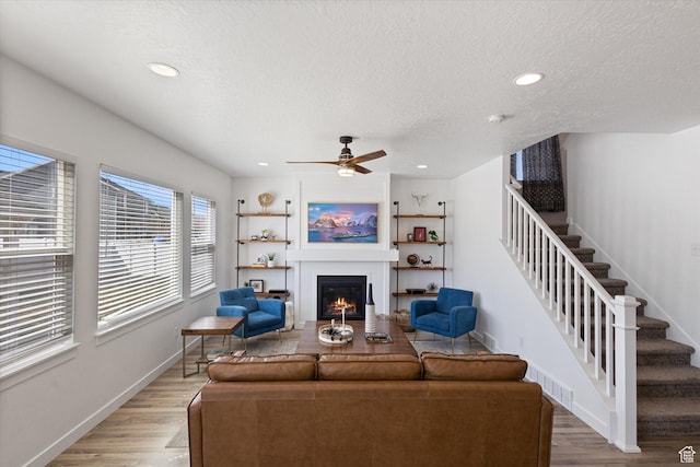 283 E Echo Ledge Dr S, Saratoga Springs, UT 84045 - living area with a textured ceiling, light wood finished floors, and stairway
