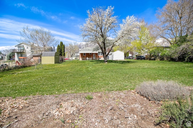 view of yard featuring an outbuilding, fence, and a storage unit