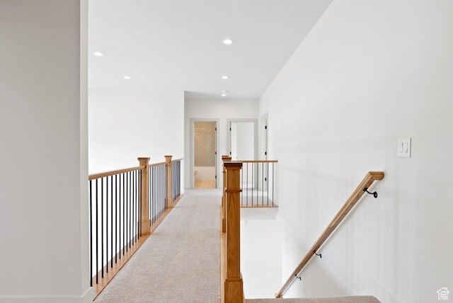 corridor featuring carpet, an upstairs landing, and recessed lighting