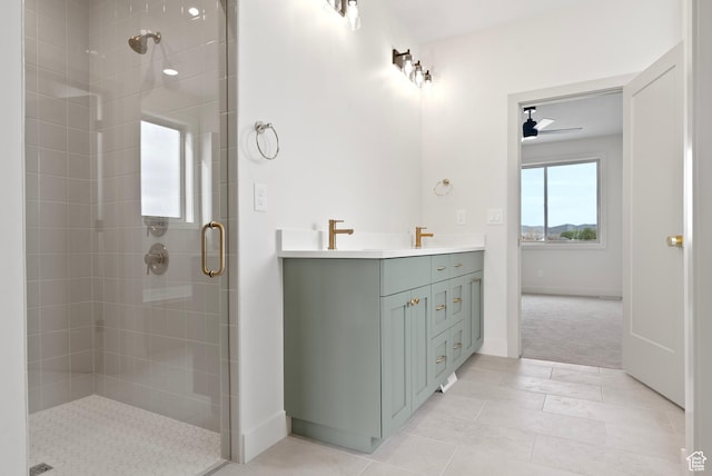full bath with double vanity, a stall shower, tile patterned flooring, a ceiling fan, and a sink