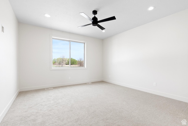 spare room with light carpet, ceiling fan, baseboards, and recessed lighting