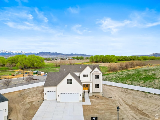 exterior space with a mountain view, fence, a garage, and driveway