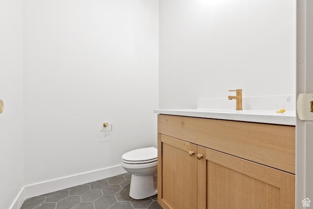 bathroom featuring tile patterned floors, toilet, vanity, and baseboards