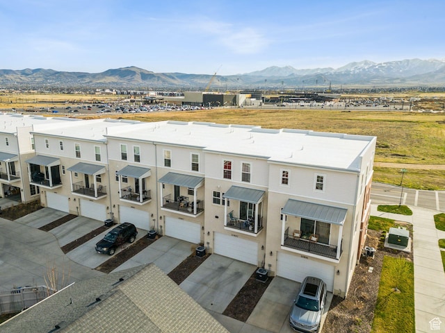 view of front facade with an attached garage, a mountain view, stucco siding, and driveway