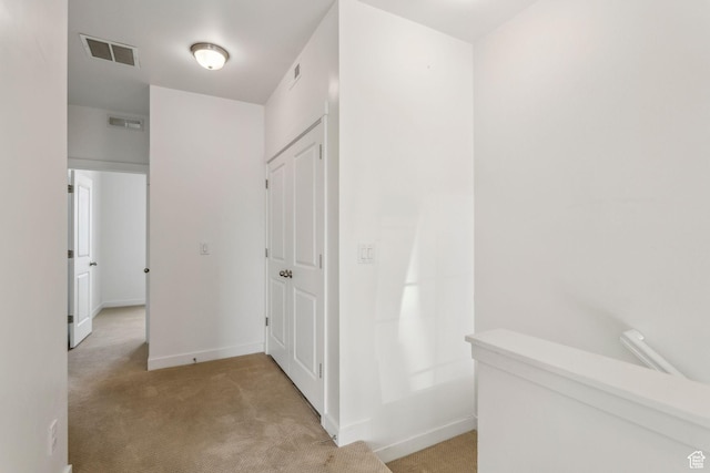 corridor featuring carpet flooring, baseboards, and visible vents