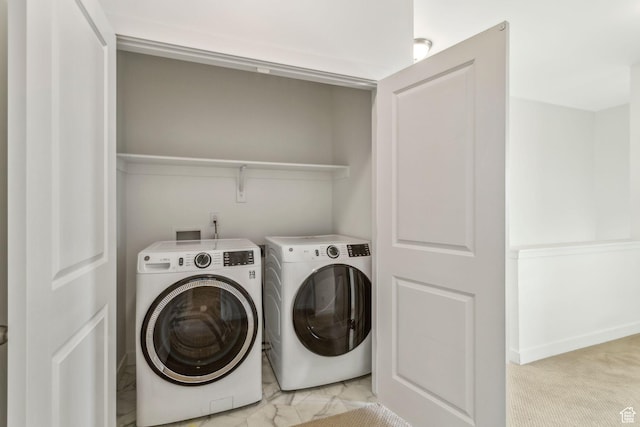 laundry room with washer and clothes dryer, marble finish floor, and laundry area