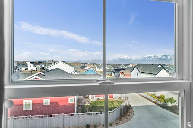 property view of water with fence, a residential view, and a mountain view