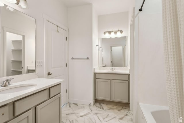 bathroom with two vanities, shower / bath combination with curtain, marble finish floor, and a sink