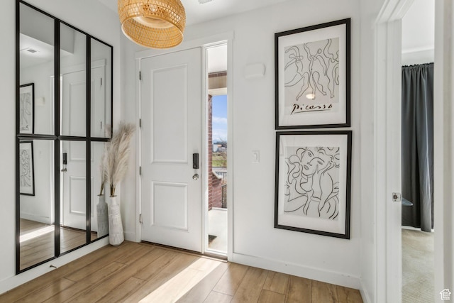 entryway featuring baseboards and wood finished floors