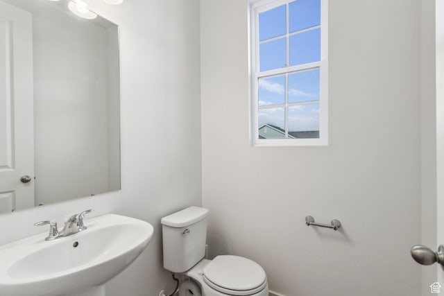 half bath featuring toilet and a sink