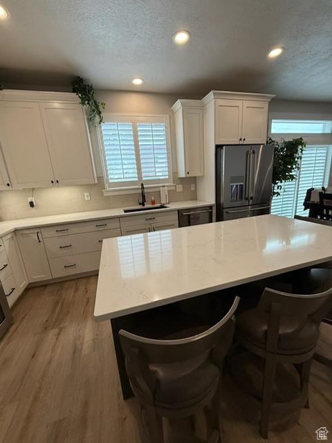 328 E 1100 S, Centerville, UT 84014 - kitchen featuring a breakfast bar area, stainless steel fridge with ice dispenser, a sink, and recessed lighting