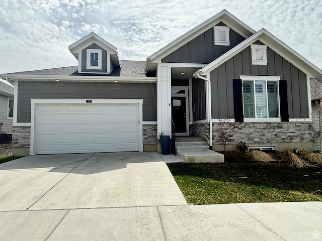 craftsman-style home featuring an attached garage, board and batten siding, concrete driveway, and stone siding