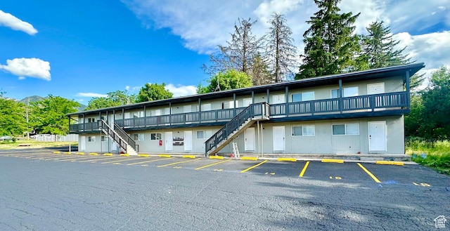 view of building exterior with uncovered parking and stairs
