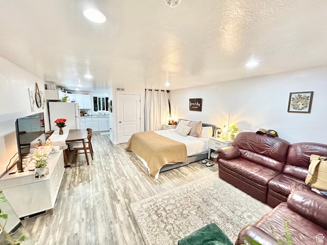 331 N 400 E, Logan, UT 84321 - bedroom with freestanding refrigerator and light wood-style floors