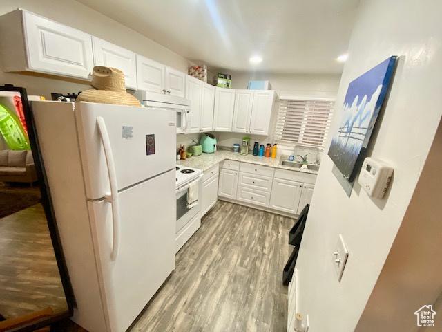 331 N 400 E, Logan, UT 84321 - kitchen with white appliances, white cabinetry, light countertops, light wood finished floors, and a sink