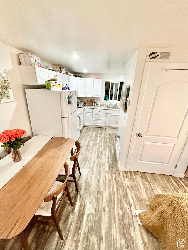 331 N 400 E, Logan, UT 84321 - kitchen with white cabinets, light wood-type flooring, light countertops, and visible vents