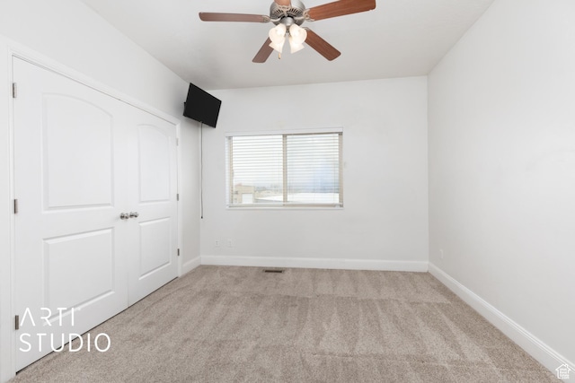 unfurnished bedroom with carpet flooring, visible vents, baseboards, and a ceiling fan