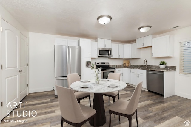 kitchen featuring visible vents, baseboards, appliances with stainless steel finishes, and wood finished floors