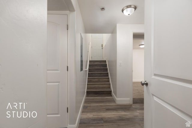 stairway with wood finished floors and baseboards