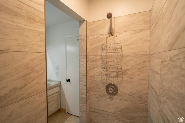 bathroom featuring a tile shower and vanity