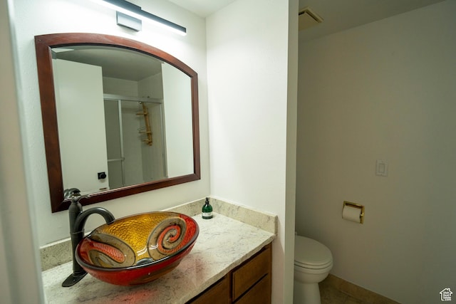 full bathroom featuring toilet, vanity, and a stall shower