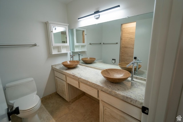 full bathroom with a sink, toilet, and double vanity