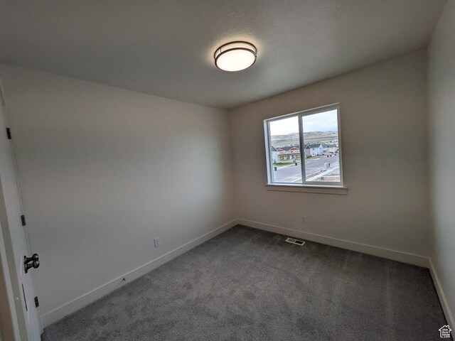 340 N 2650 W Unit 16, Tremonton, UT 84337 - unfurnished room with visible vents, baseboards, and dark colored carpet