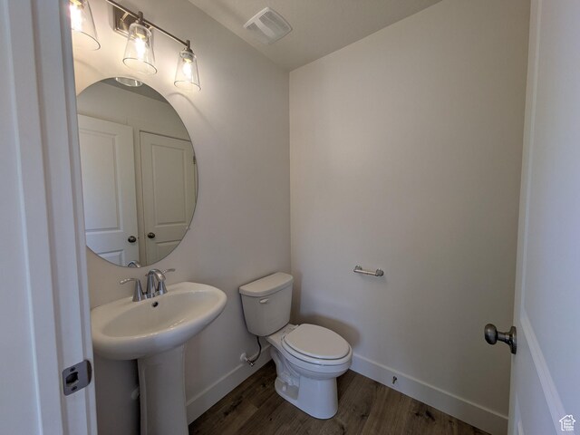 340 N 2650 W Unit 16, Tremonton, UT 84337 - half bath featuring visible vents, baseboards, a sink, toilet, and wood finished floors