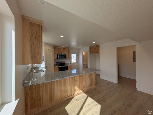 340 N 2650 W Unit 16, Tremonton, UT 84337 - kitchen with visible vents, a peninsula, light wood finished floors, light stone countertops, and stainless steel electric range