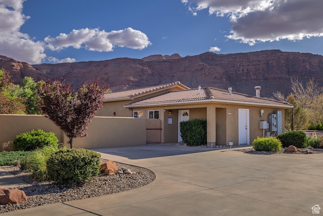 327 W Williams Way, Moab, UT 84532 - view of front of home with curved driveway, a mountain view, stucco siding, and a tile roof