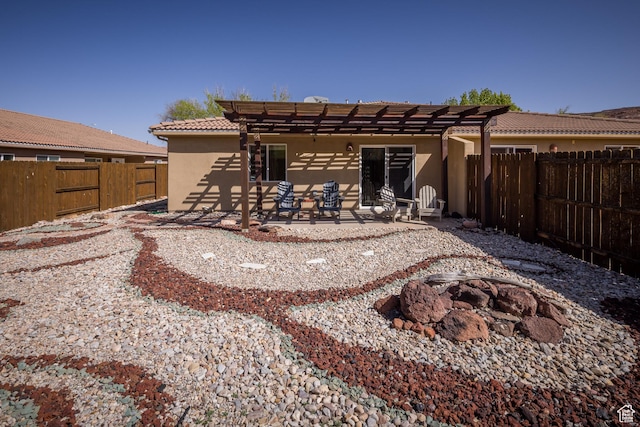 327 W Williams Way, Moab, UT 84532 - back of house with a tiled roof, a fenced backyard, a pergola, a fire pit, and stucco siding