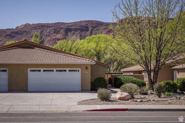 327 W Williams Way, Moab, UT 84532 - view of front of home featuring a mountain view, stucco siding, driveway, and a tiled roof
