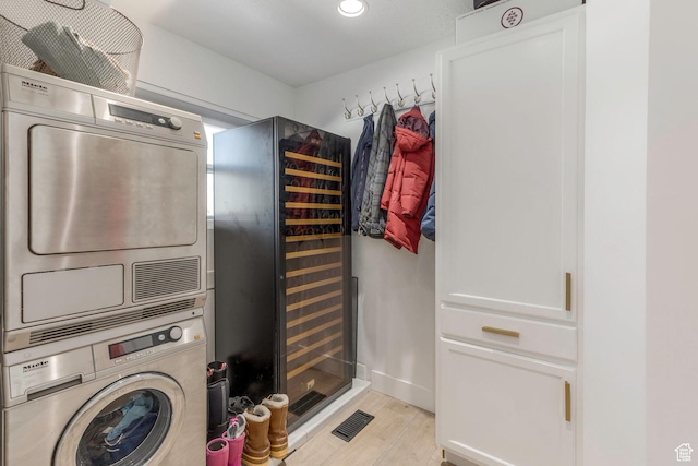528 W Weber Canyon Rd, Oakley, UT 84055 - laundry room featuring stacked washer / drying machine, light wood-style floors, beverage cooler, recessed lighting, and baseboards