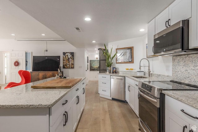 528 W Weber Canyon Rd, Oakley, UT 84055 - kitchen with stainless steel appliances, a sink, light wood-type flooring, recessed lighting, and white cabinetry