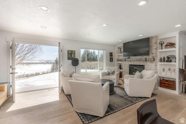 528 W Weber Canyon Rd, Oakley, UT 84055 - living room with recessed lighting, a textured ceiling, a fireplace, light wood-style floors, and built in shelves