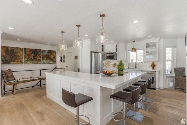 528 W Weber Canyon Rd, Oakley, UT 84055 - kitchen with stainless steel appliances, light wood finished floors, recessed lighting, light countertops, and white cabinets