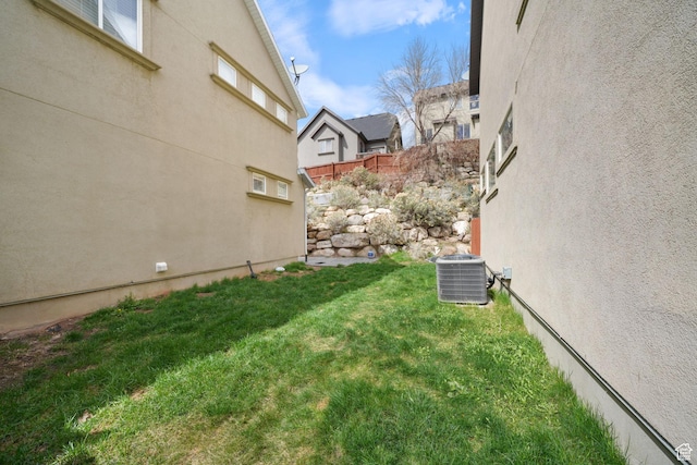 view of yard featuring central AC unit and fence