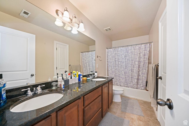 bathroom featuring double vanity, visible vents, a sink, and toilet