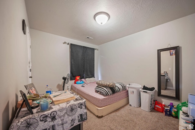 carpeted bedroom with a textured ceiling and visible vents