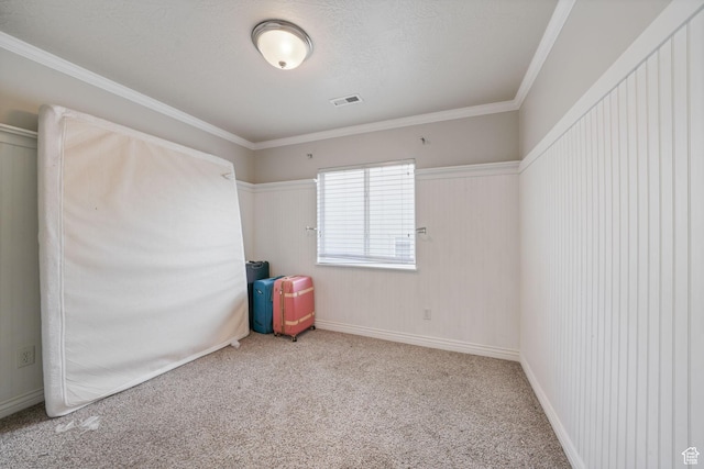 carpeted spare room with crown molding and visible vents
