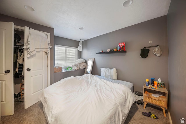carpeted bedroom featuring a walk in closet