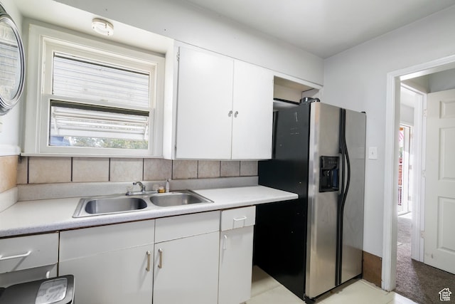 1604 Childs Ave, Ogden, UT 84404 - kitchen with stainless steel fridge, a sink, light countertops, white cabinetry, and decorative backsplash