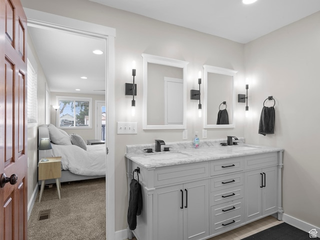 bathroom featuring visible vents, baseboards, a sink, and ensuite bathroom