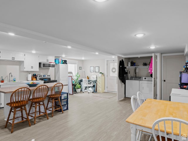 dining space featuring recessed lighting, washer and dryer, and light wood-style floors