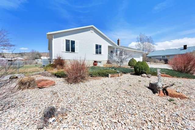 154 W Main St, Bicknell, UT 84715 - view of front of home with an attached garage, a chimney, and fence