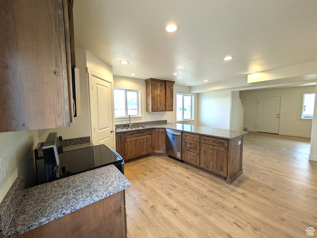 kitchen featuring light wood-style floors, stainless steel dishwasher, a peninsula, a sink, and black electric range oven