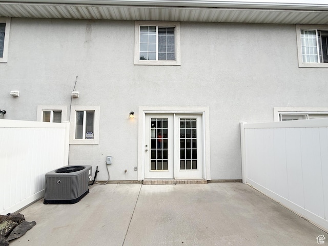 back of property with a patio area, central air condition unit, fence, and stucco siding
