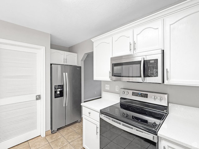 kitchen featuring white cabinets, light countertops, appliances with stainless steel finishes, and light tile patterned flooring